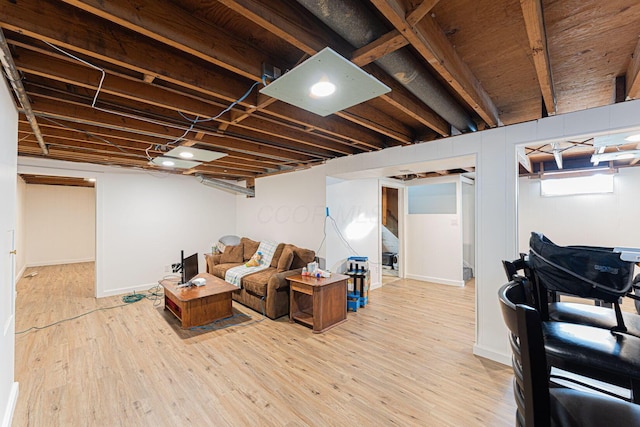 finished basement with baseboards and light wood-style floors