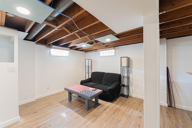 living area with baseboards, a healthy amount of sunlight, and light wood-style flooring