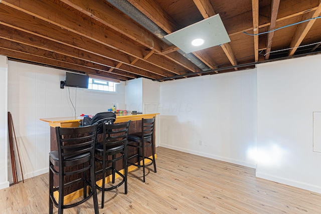 bar featuring baseboards, a dry bar, and wood finished floors