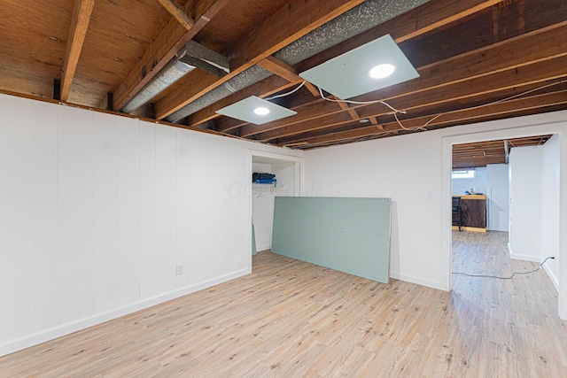finished below grade area featuring baseboards and wood finished floors