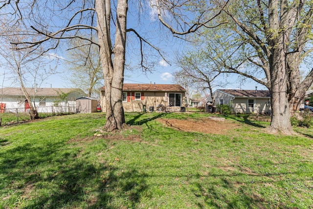view of yard with a storage shed, fence, and an outdoor structure
