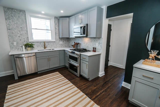 568 Cline St, Columbus, OH 43206 - kitchen with stainless steel appliances, a sink, baseboards, gray cabinetry, and tasteful backsplash