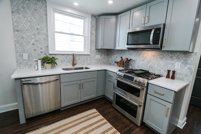 568 Cline St, Columbus, OH 43206 - kitchen with tasteful backsplash, a sink, appliances with stainless steel finishes, dark wood-style flooring, and gray cabinetry