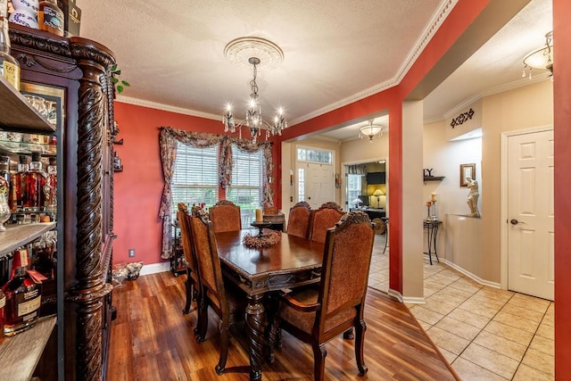 8181 Trail Lake Dr, Powell, OH 43065 - dining area featuring a textured ceiling, a chandelier, baseboards, ornamental molding, and tile patterned flooring