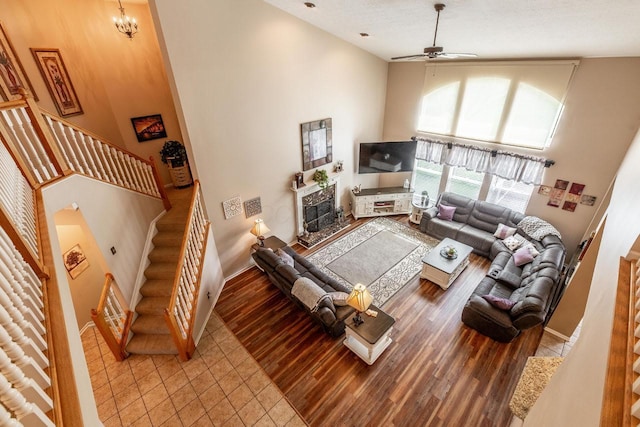 8181 Trail Lake Dr, Powell, OH 43065 - living room with a towering ceiling, a ceiling fan, tile patterned flooring, stairs, and a high end fireplace