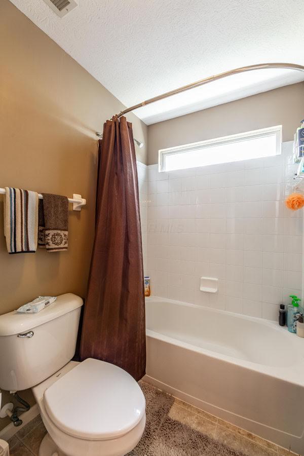 8181 Trail Lake Dr, Powell, OH 43065 - bathroom with shower / tub combo, toilet, tile patterned floors, and a wealth of natural light
