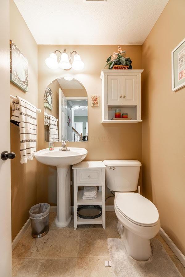 8181 Trail Lake Dr, Powell, OH 43065 - half bathroom with tile patterned flooring, toilet, baseboards, and a sink