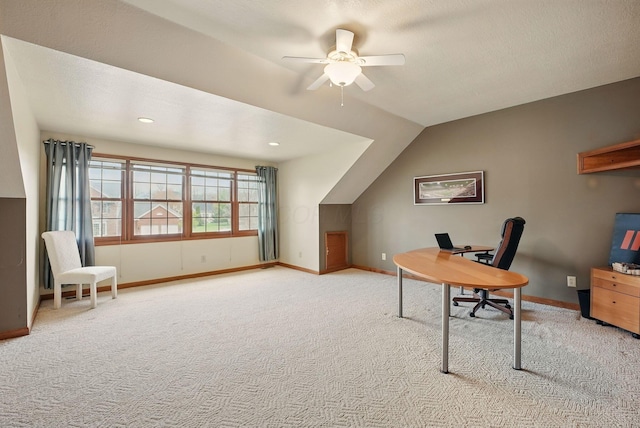 carpeted office with lofted ceiling, a ceiling fan, and baseboards