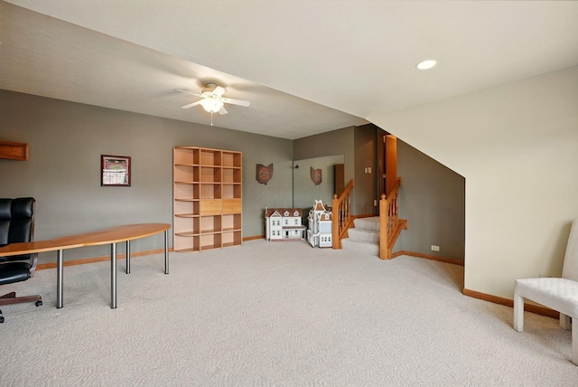 carpeted office space featuring baseboards and ceiling fan