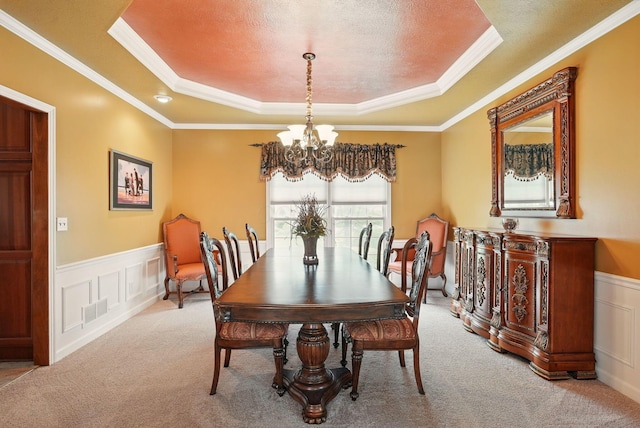 dining area featuring an inviting chandelier, visible vents, carpet floors, and a raised ceiling