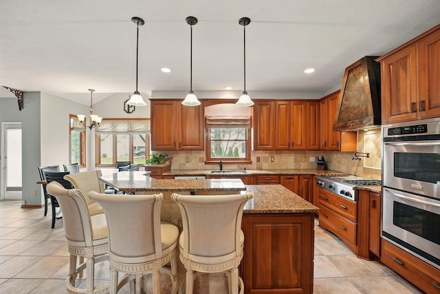 kitchen with tasteful backsplash, a sink, stainless steel appliances, and custom range hood