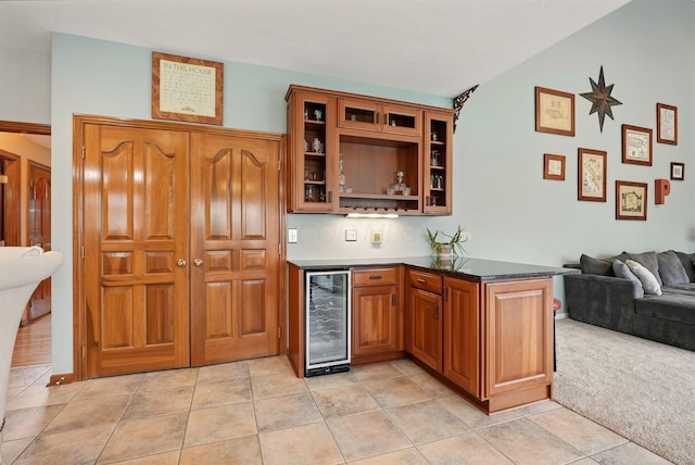 bar featuring lofted ceiling, wine cooler, light tile patterned floors, and wet bar