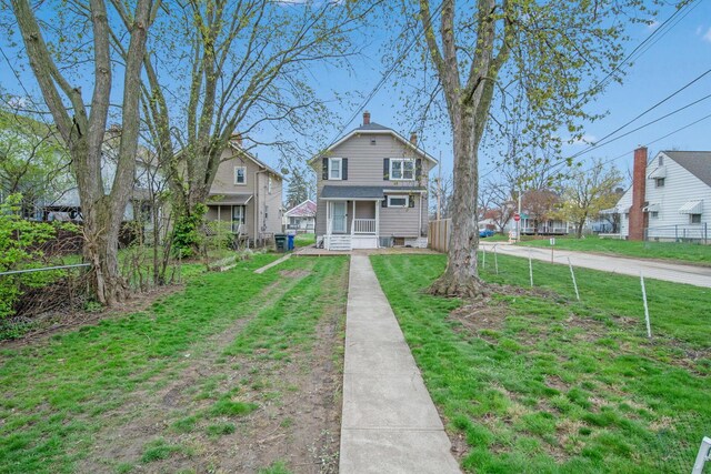 view of front of property featuring a front lawn, covered porch, and a residential view