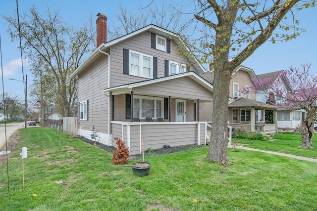 traditional style home featuring a porch, a front lawn, and a chimney