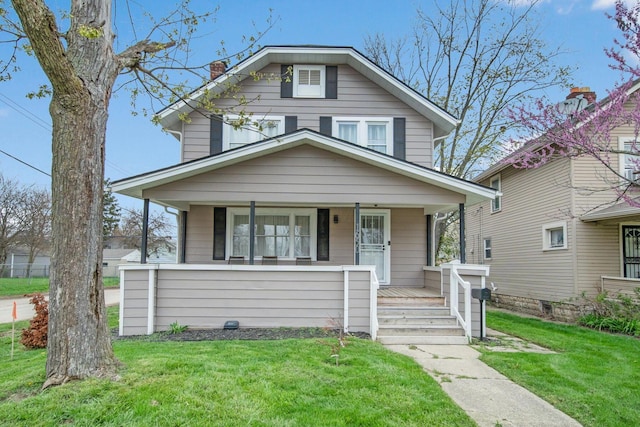 american foursquare style home with a porch and a front lawn