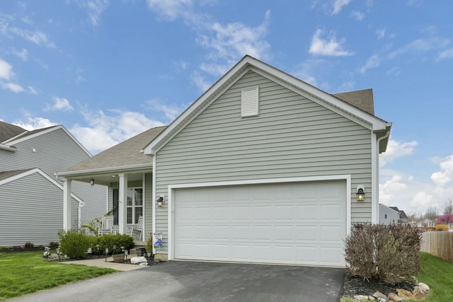 114 Hummock Dr, Etna, OH 43062 - view of front of house with a garage, driveway, covered porch, a front yard, and roof with shingles