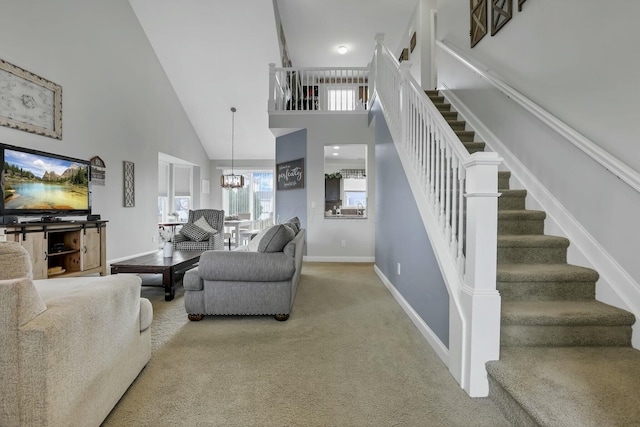114 Hummock Dr, Etna, OH 43062 - living room featuring high vaulted ceiling, stairway, a chandelier, carpet, and baseboards