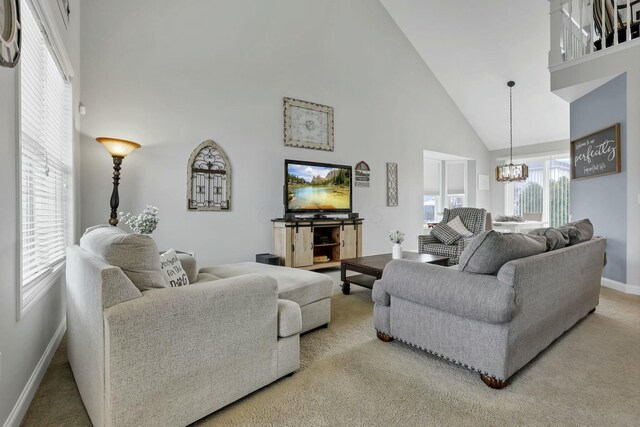 114 Hummock Dr, Etna, OH 43062 - living room with a chandelier, baseboards, high vaulted ceiling, and light colored carpet