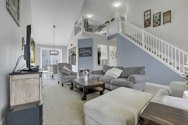 114 Hummock Dr, Etna, OH 43062 - carpeted living room featuring stairway, a high ceiling, baseboards, and a notable chandelier