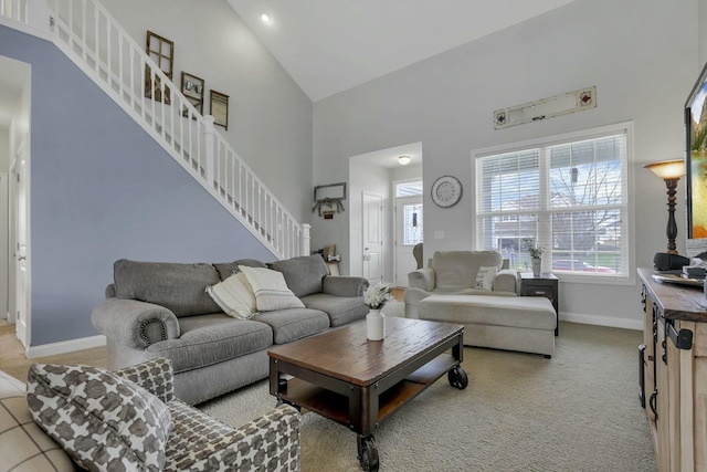 114 Hummock Dr, Etna, OH 43062 - living area with high vaulted ceiling, baseboards, light carpet, and stairway