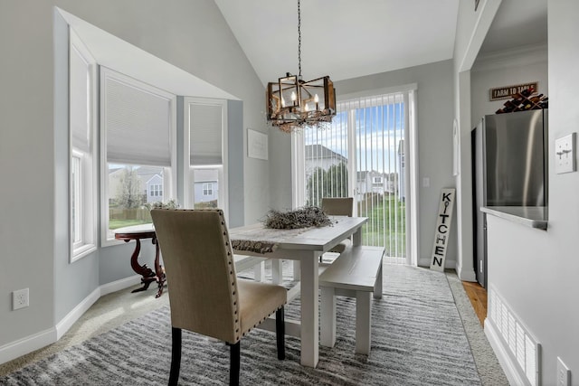 114 Hummock Dr, Etna, OH 43062 - dining area featuring an inviting chandelier, vaulted ceiling, and baseboards