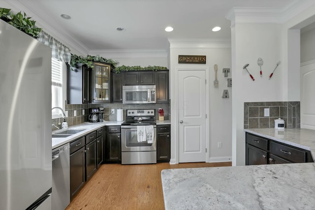 114 Hummock Dr, Etna, OH 43062 - kitchen with light wood finished floors, stainless steel appliances, a sink, tasteful backsplash, and light stone countertops