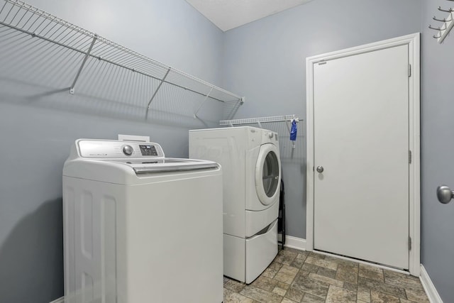 114 Hummock Dr, Etna, OH 43062 - clothes washing area featuring stone finish flooring, baseboards, washer and clothes dryer, and laundry area