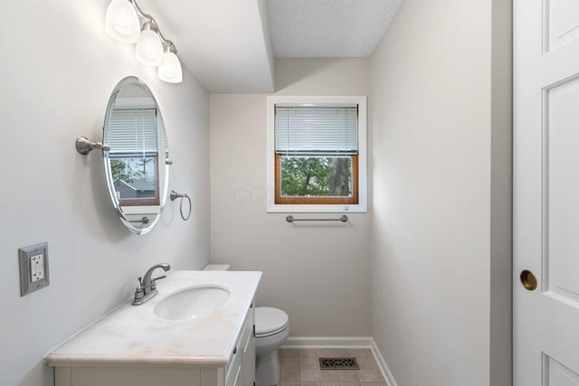 bathroom featuring toilet, vanity, baseboards, and tile patterned floors