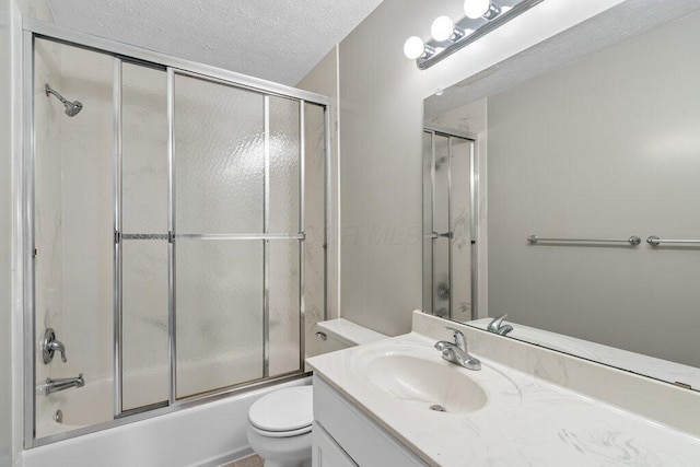bathroom with toilet, vanity, a textured ceiling, and enclosed tub / shower combo