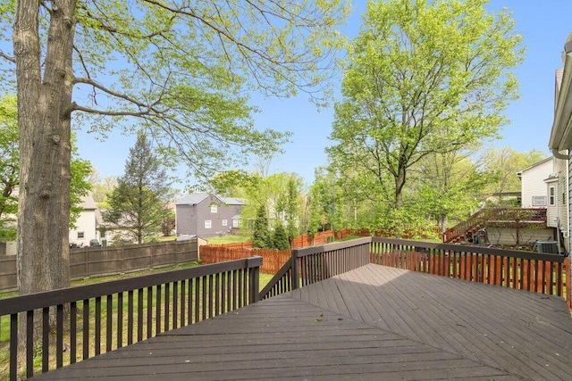 wooden deck with a fenced backyard, cooling unit, and a residential view