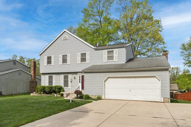 view of front of home with driveway, a front lawn, a chimney, and an attached garage