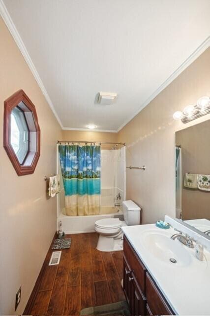 bathroom featuring shower / tub combo, toilet, ornamental molding, wood finished floors, and vanity
