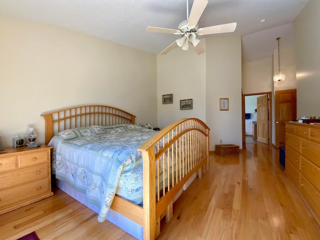 bedroom featuring light wood finished floors, ceiling fan, and lofted ceiling