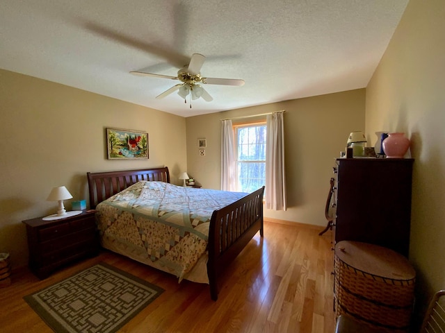 bedroom with light wood-style flooring, baseboards, and ceiling fan