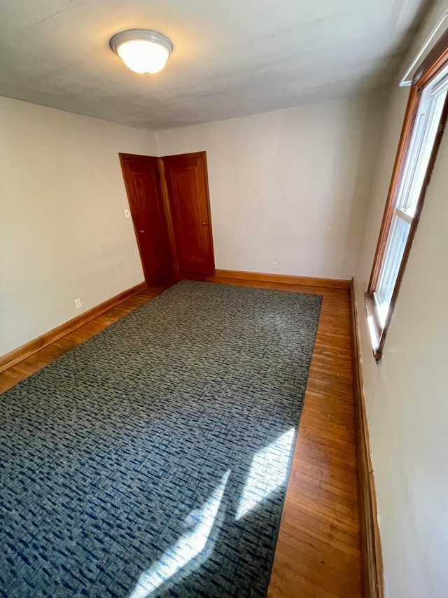 unfurnished room with wood finished floors and baseboards