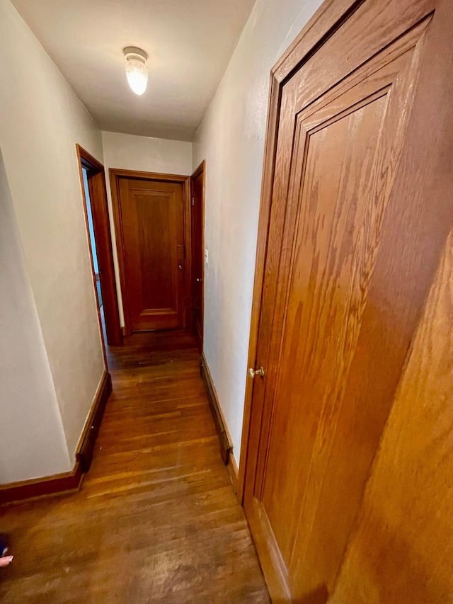 hallway with wood finished floors and baseboards