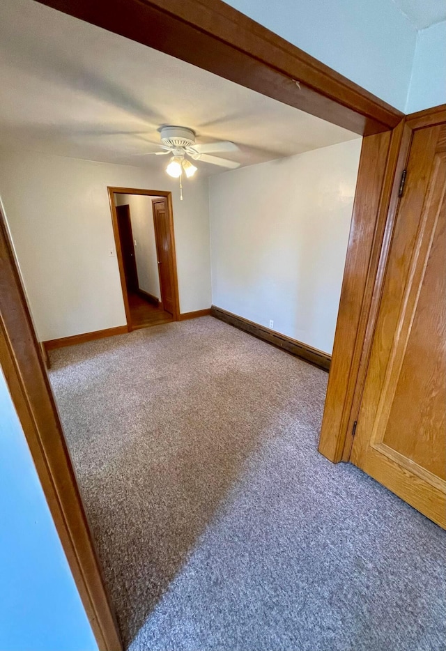 unfurnished room featuring carpet, baseboards, and ceiling fan