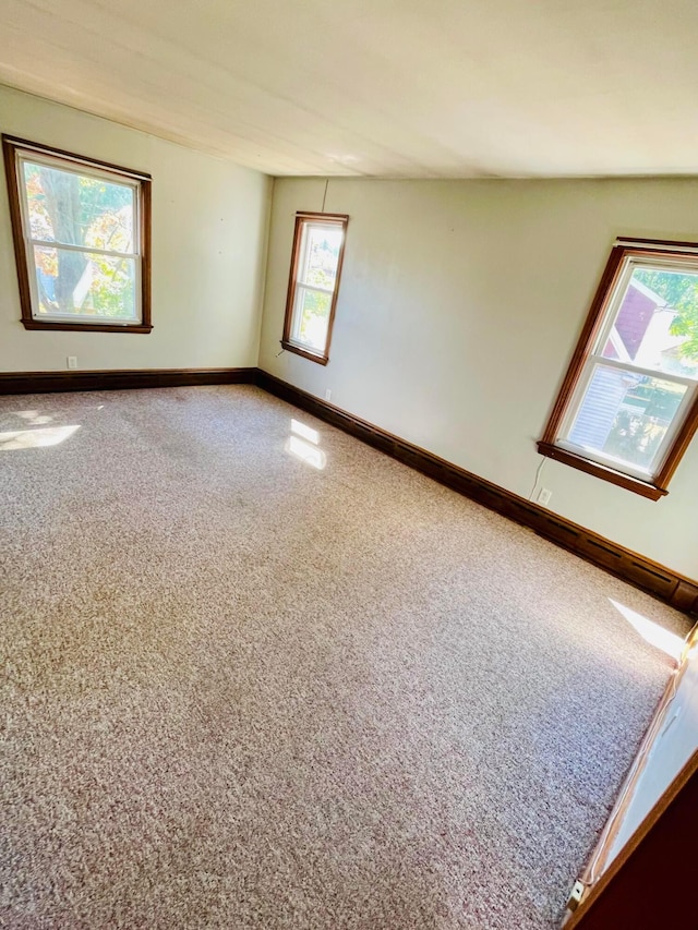 carpeted spare room featuring baseboards