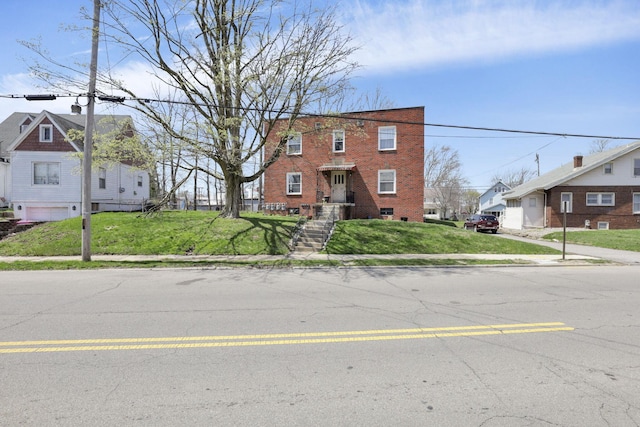 view of front of property featuring brick siding and a front lawn