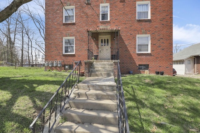 view of front facade with brick siding and a front yard