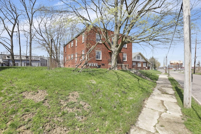 view of home's exterior featuring brick siding and fence