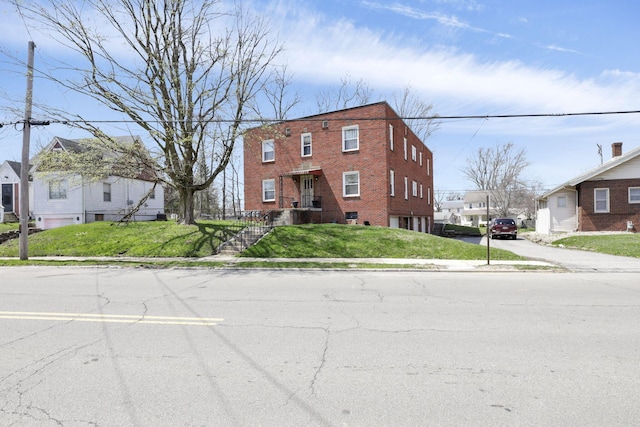 view of property featuring a front lawn and brick siding