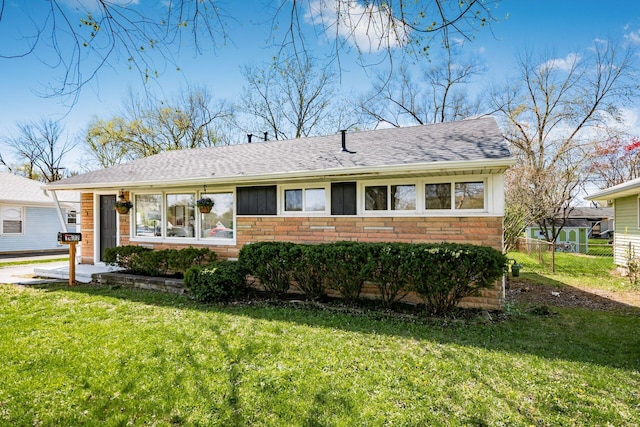single story home with a front lawn, fence, and stone siding