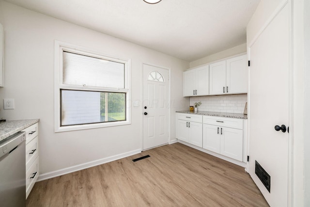 kitchen with light wood-type flooring, white cabinetry, stainless steel dishwasher, and decorative backsplash