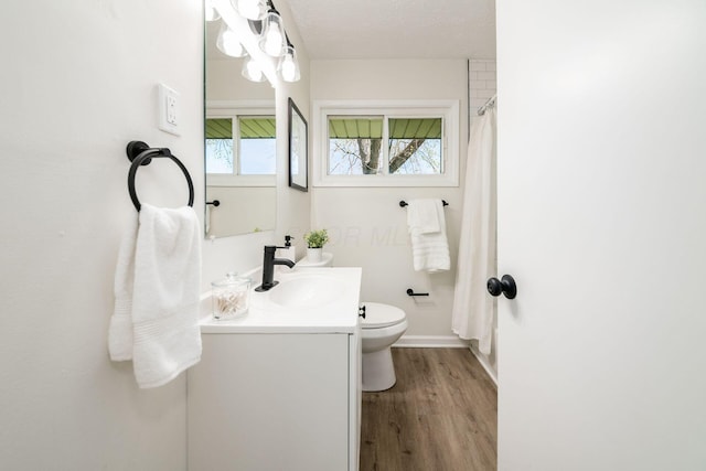 full bath featuring curtained shower, wood finished floors, toilet, vanity, and baseboards