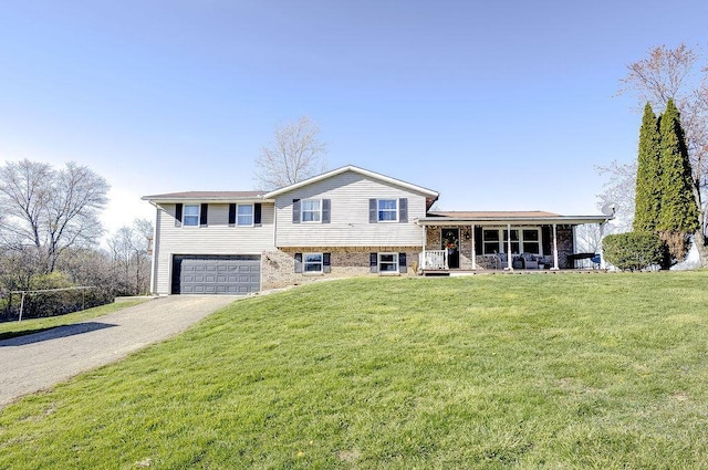split level home featuring an attached garage, gravel driveway, a porch, and a front lawn