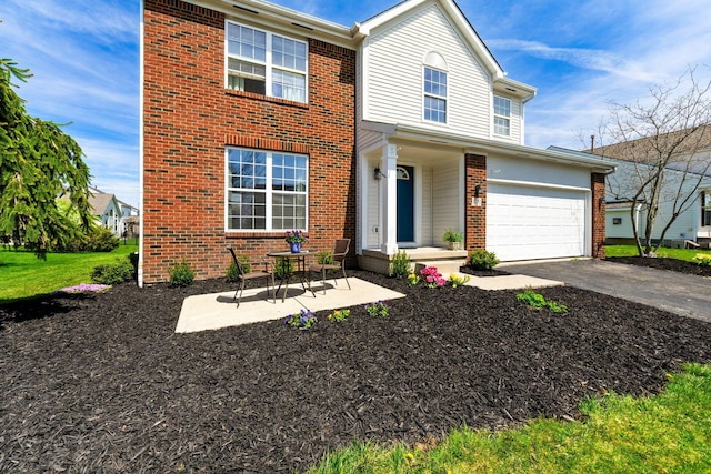 traditional-style house with brick siding, driveway, and a garage
