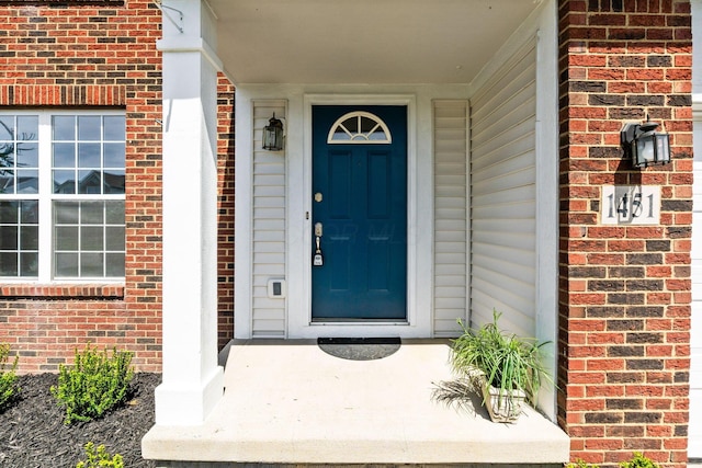 entrance to property featuring brick siding
