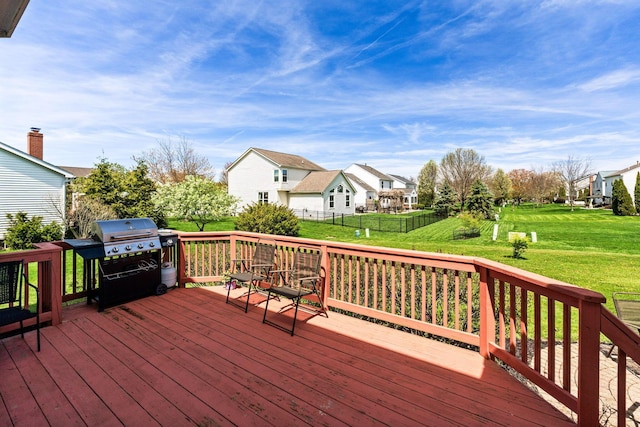 wooden deck with a yard, area for grilling, a residential view, and fence