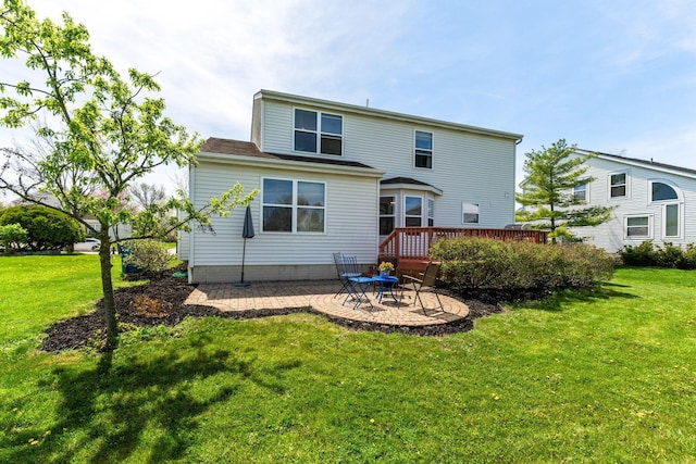 back of house with a wooden deck, a lawn, and a patio
